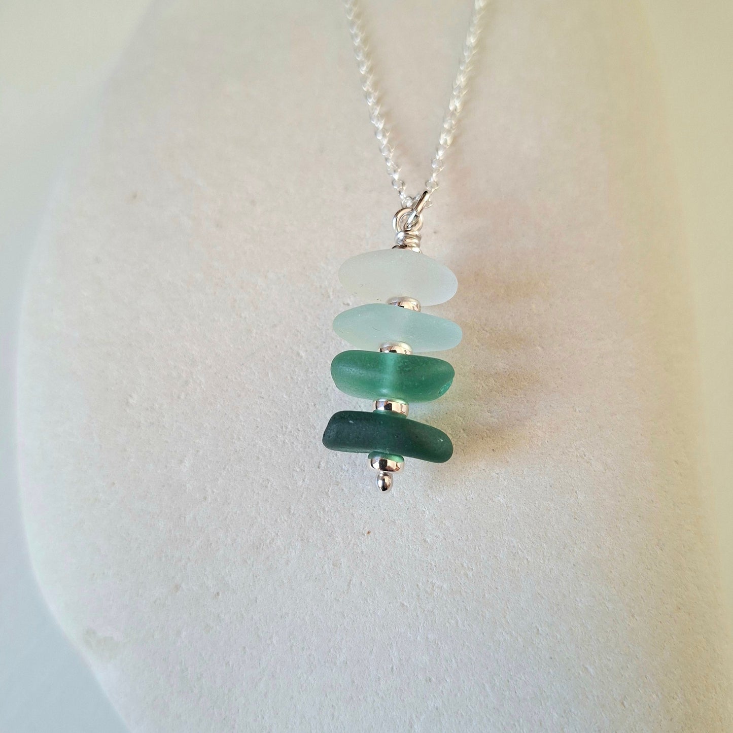 Silver necklace with a pendant made with 4 pieces of sea glass in coastal shades.