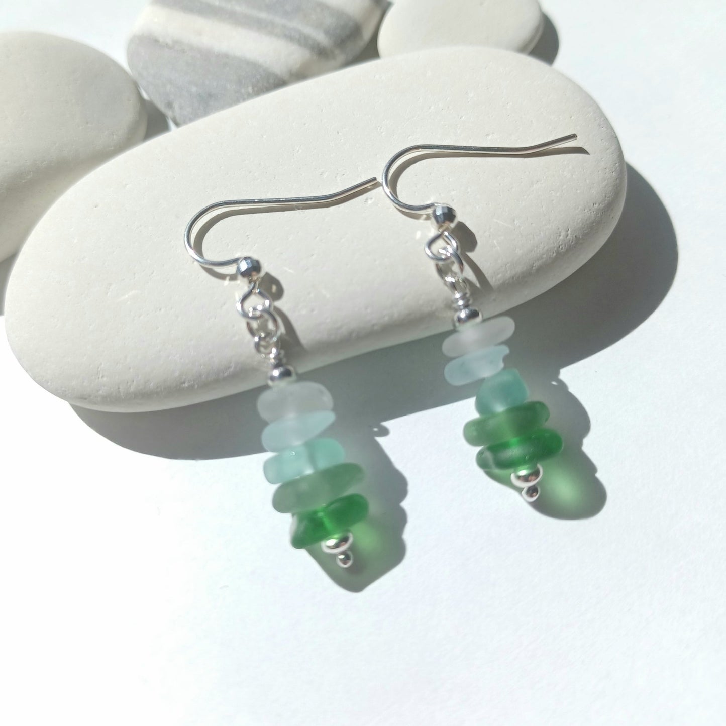 A pair of silver earrings with a mini stack of five pieces of sea glass on each earring.