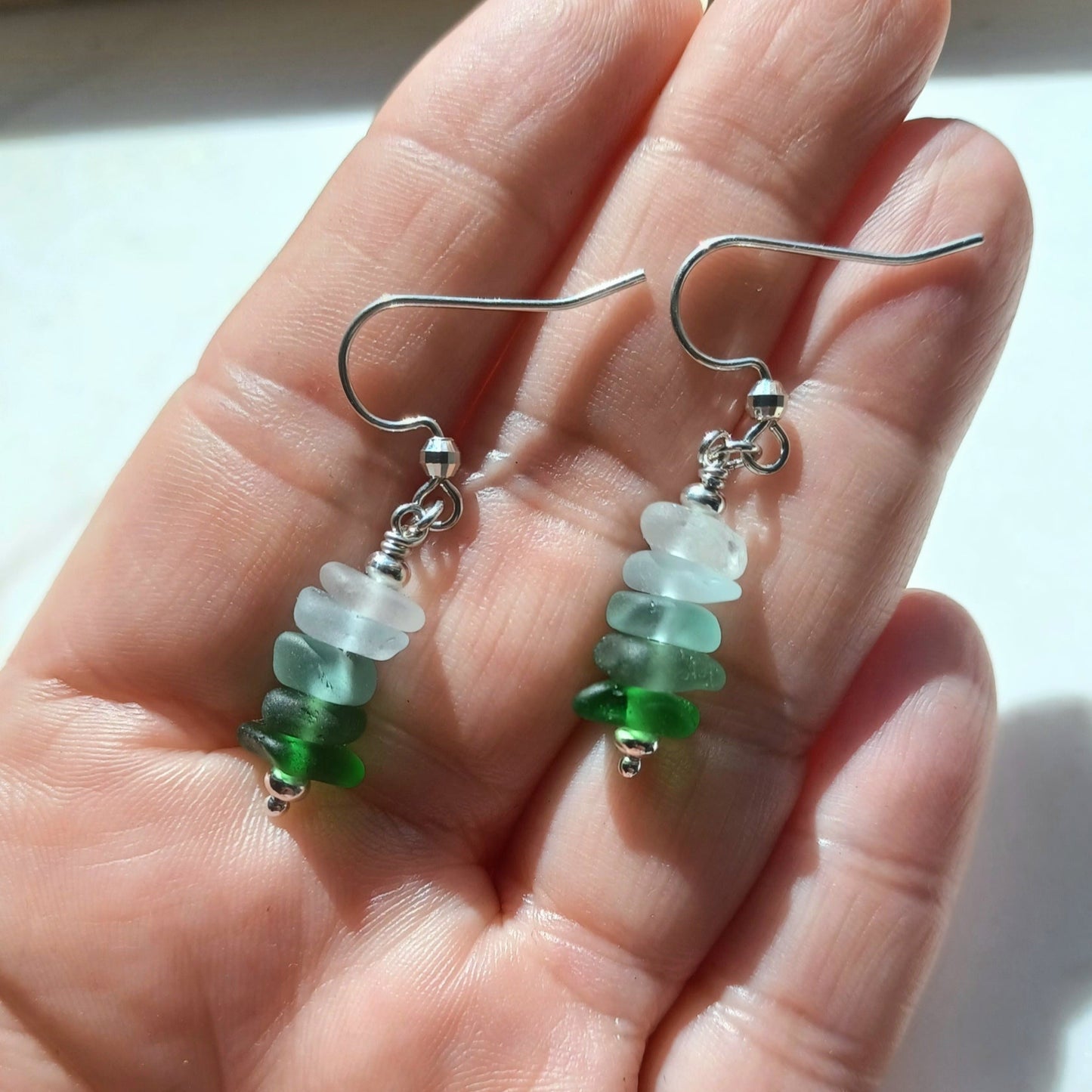 A pair of silver earrings with a mini stack of five pieces of sea glass on each earring.