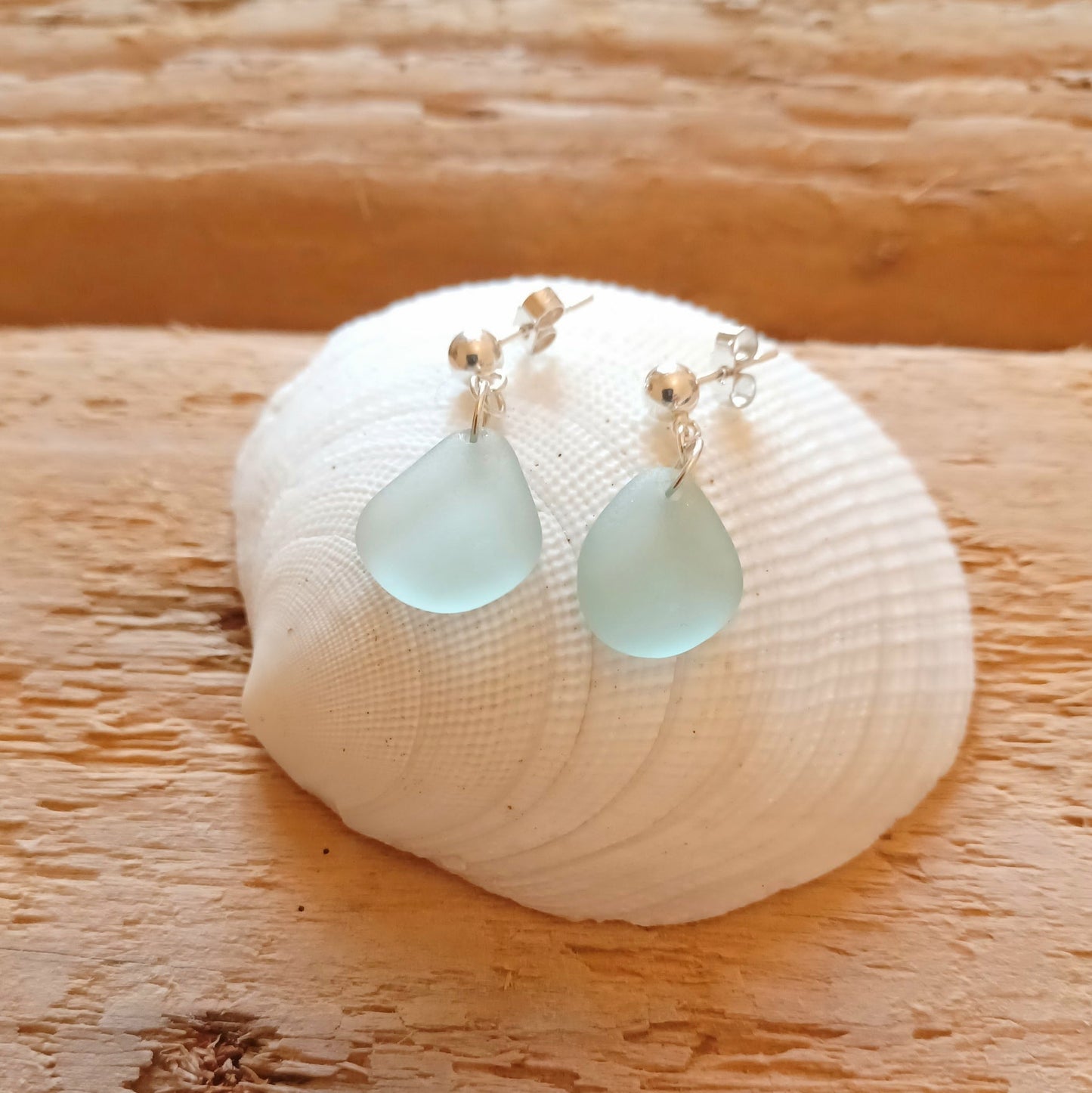 A pair of sterling silver sea foam sea glass drop earrings.
