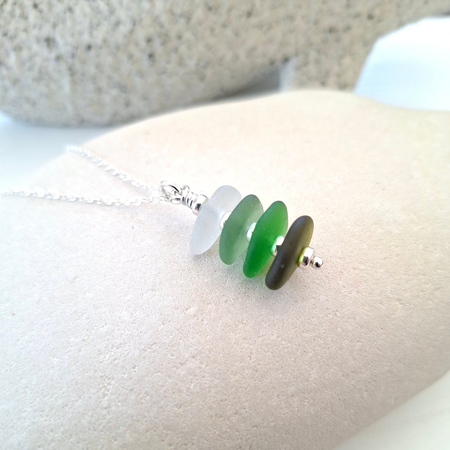 Silver necklace with a pendant made with 4 pieces of sea glass in shades of green, made in Cyprus.