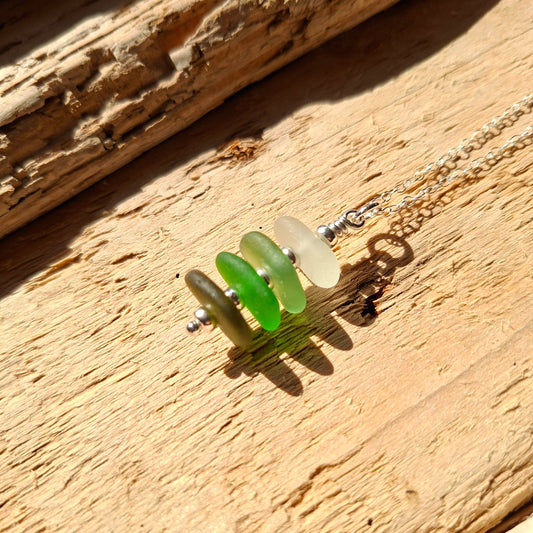 Silver necklace with a pendant made with 4 pieces of sea glass in shades of green.