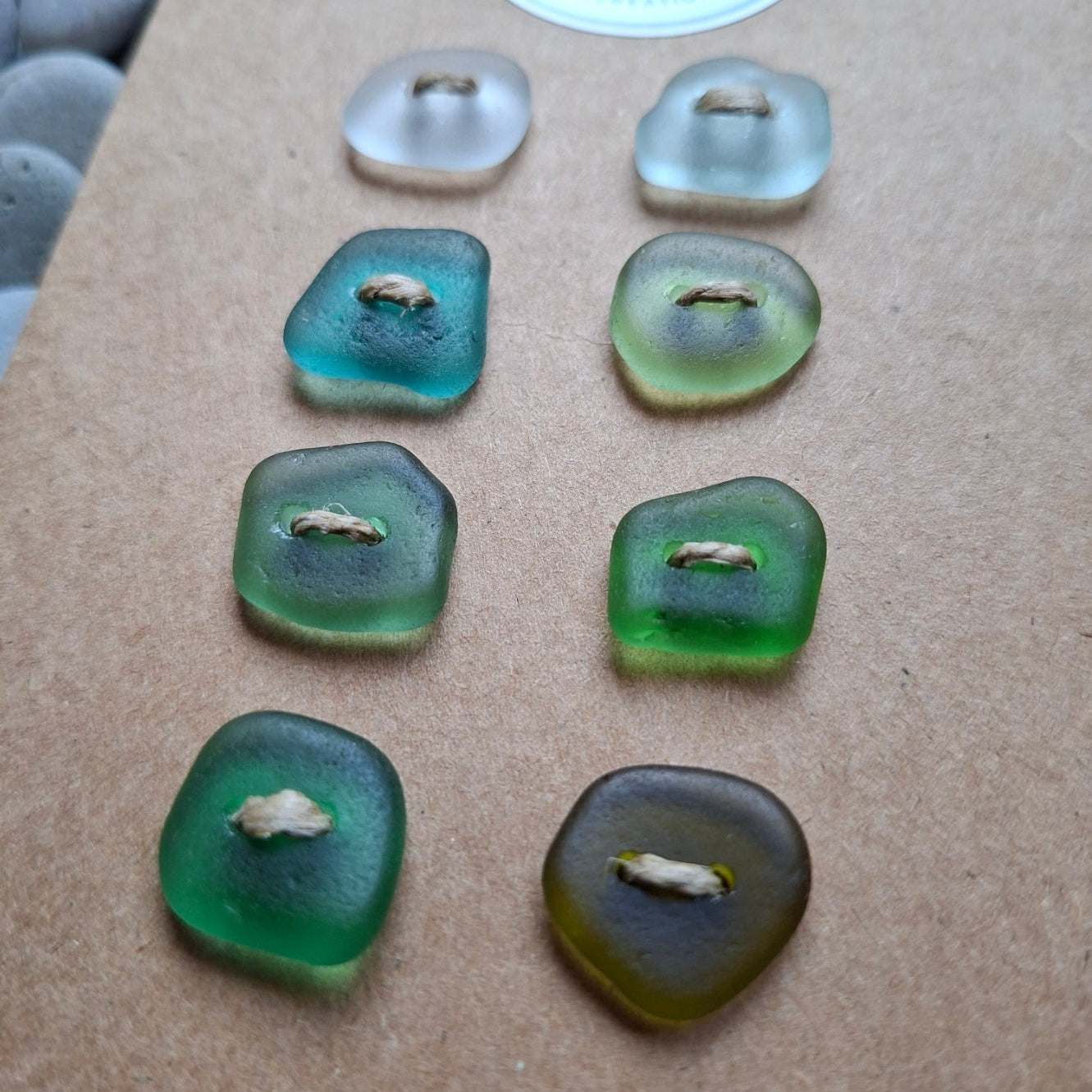 A set of eight sea glass buttons in various coastal colours.