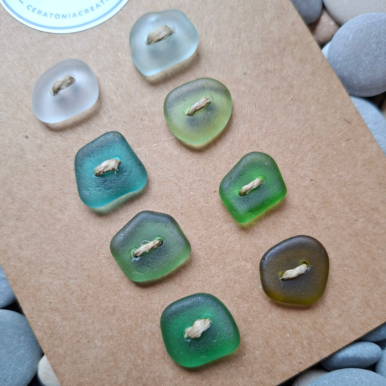 A set of eight sea glass buttons in various coastal colours.