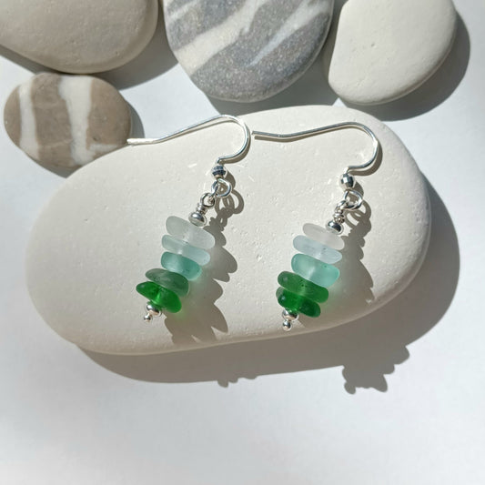A pair of silver earrings with a mini stack of five pieces of sea glass on each earring.