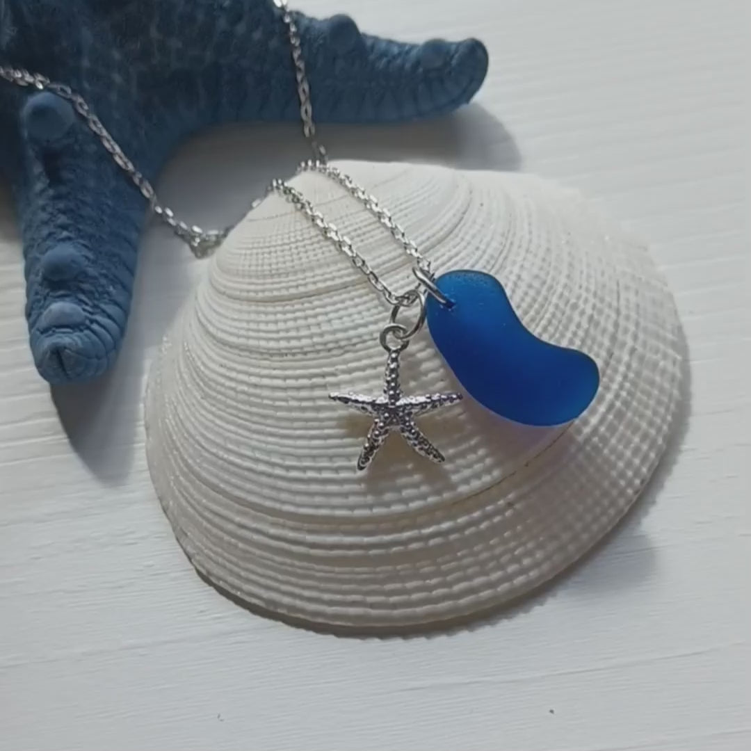 Silver necklace with a cobalt blue sea glass pendant and starfish charm.